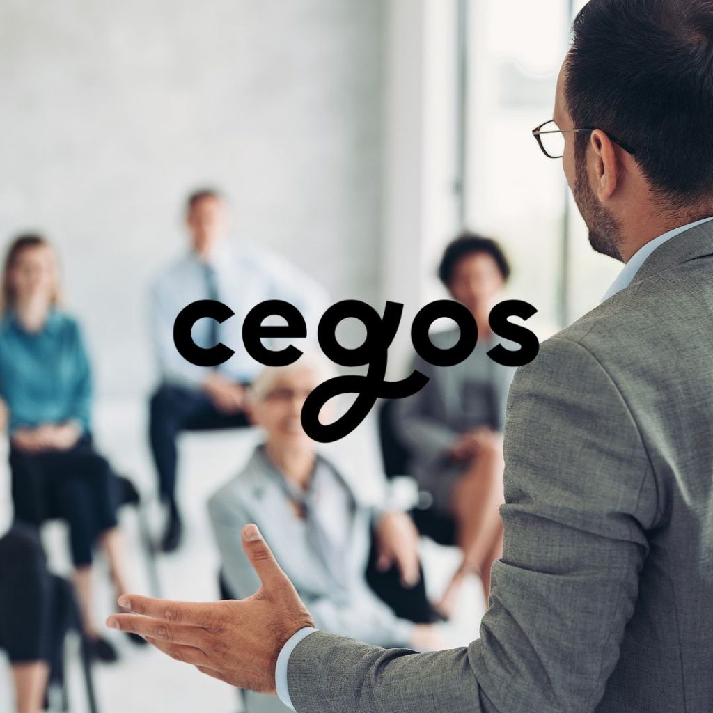 Formateur Cegos animant une session de formation professionnelle devant un groupe de participants en entreprise